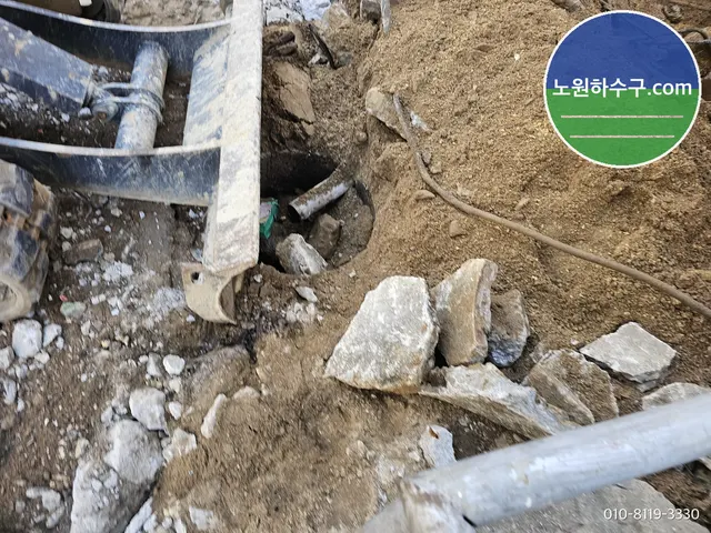 흙더미 사이 구덩이 속에 보이는 배관 끝부분